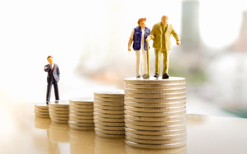 a stack of coins with figures on top of them, the young professional is on the lower part while the retired people are on the higher part